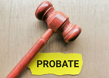 Wooden gavel with the word 'Probate' on a yellow paper background